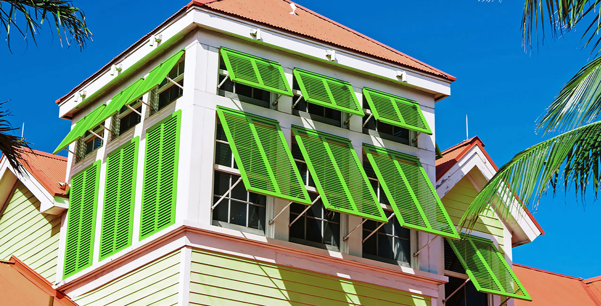 Colorful Bahama shutters open on a beautiful Palm Bay home, providing tropical style and sun protection.