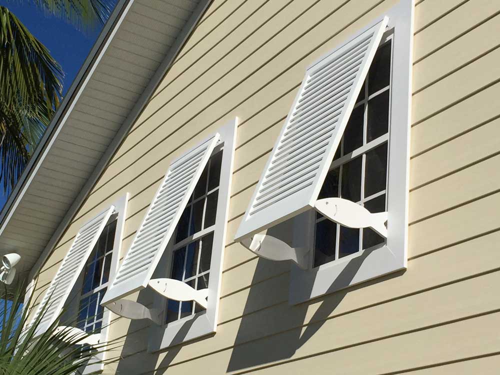 Open Fish Bahama shutters allowing natural light and airflow into a Florida home.