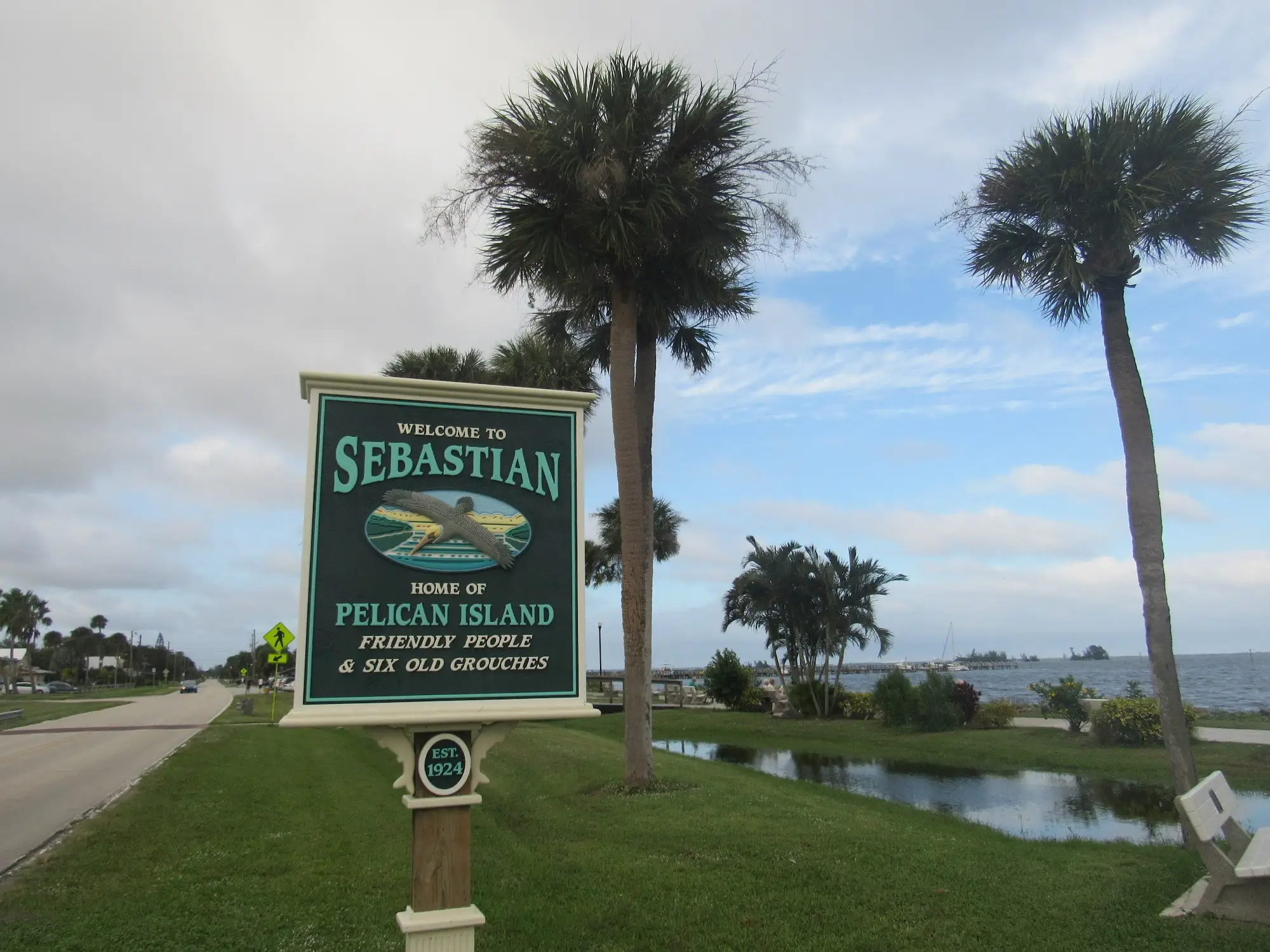 Welcome to Sebastian — large sign with Pelican Island imagery, palm trees, and water nearby.