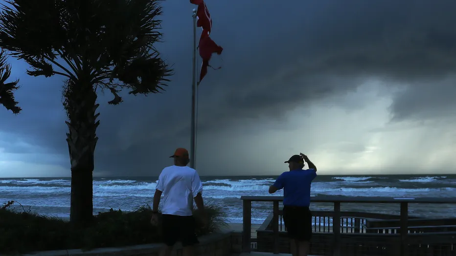 Two men observe an approaching squall caused by hurricane Dorian which is looming in the Atlantic Ocean on September 3, 2019 in Ormond Beach, Florida.